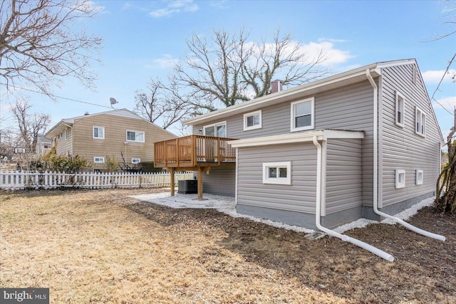 back of property with central air condition unit, a chimney, fence, and a deck