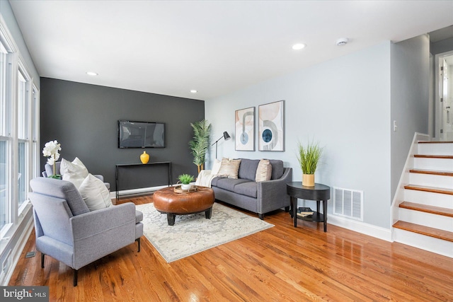 living area featuring stairs, visible vents, wood finished floors, and recessed lighting