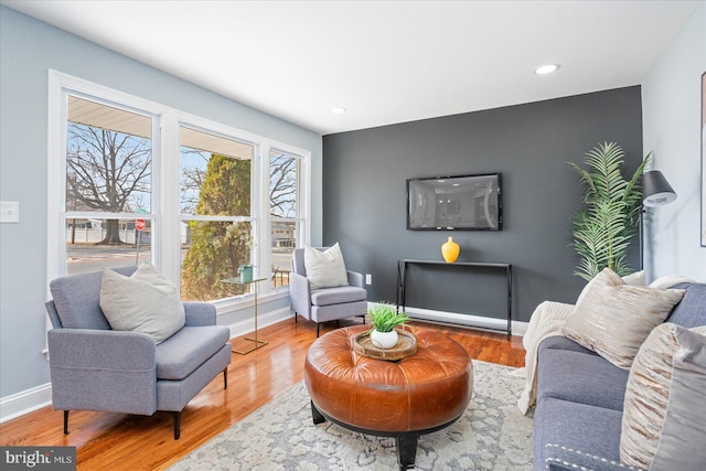 living area with baseboards, wood finished floors, and recessed lighting