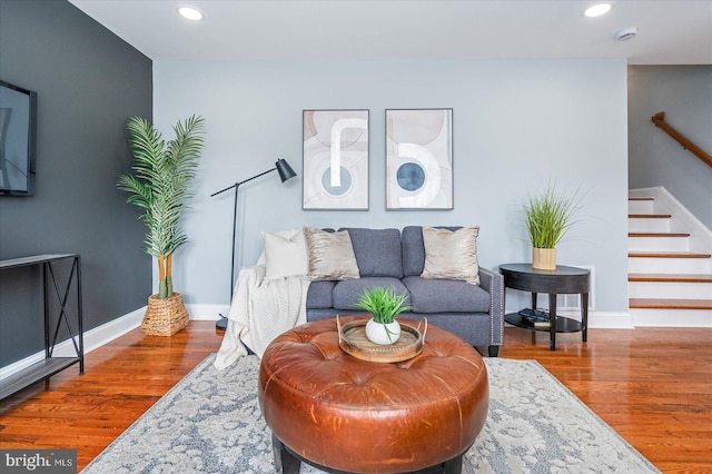 living room featuring stairway, recessed lighting, wood finished floors, and baseboards