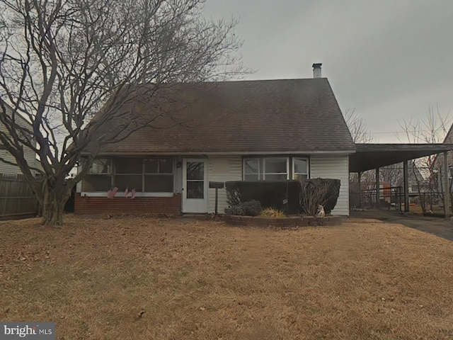 back of property featuring a carport and driveway