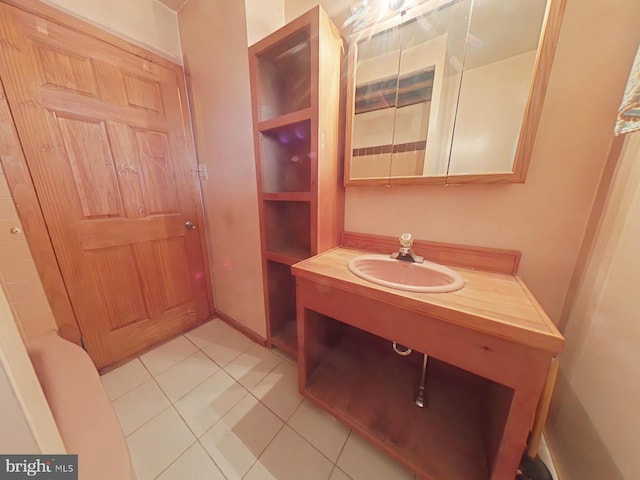 bathroom featuring vanity, baseboards, and tile patterned floors