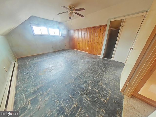 bonus room featuring ceiling fan, vaulted ceiling, baseboard heating, and dark floors