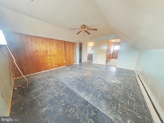 bonus room featuring a baseboard radiator, vaulted ceiling, and dark floors