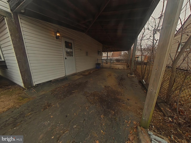 view of side of home with fence and a carport