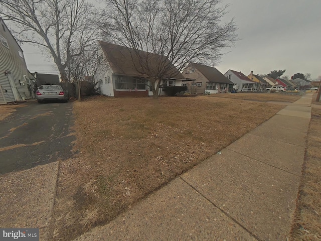 view of front of home with a residential view and aphalt driveway