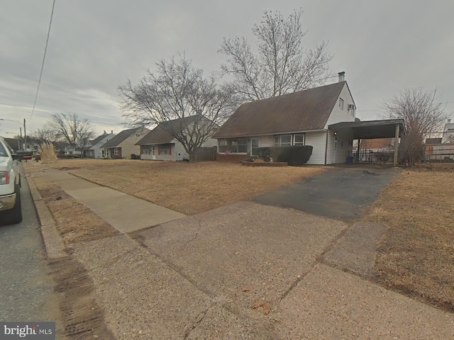 view of front of home with driveway, a carport, and a residential view