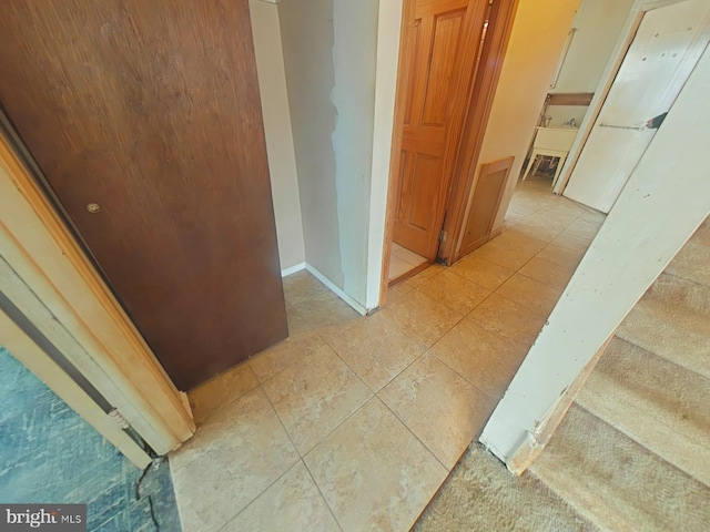 hall with light tile patterned floors and baseboards