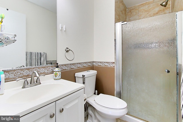 full bath featuring toilet, a stall shower, and vanity