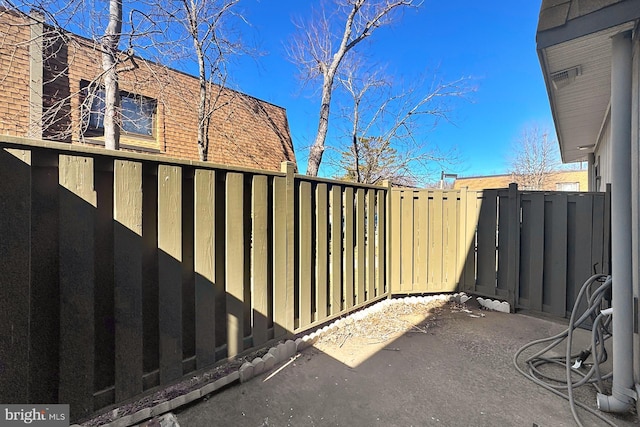 view of gate featuring a patio area and a fenced backyard