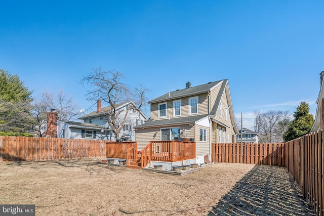 rear view of house with a deck and a fenced backyard