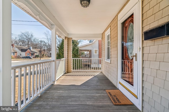 wooden terrace featuring covered porch and a residential view