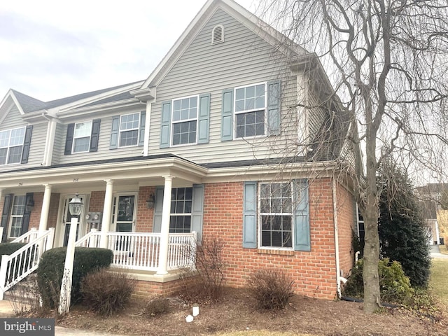 view of front facade featuring covered porch and brick siding