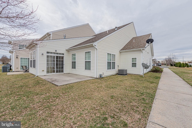 rear view of property featuring a patio area, roof with shingles, central AC, and a yard