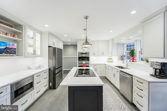 kitchen featuring appliances with stainless steel finishes, a center island, white cabinets, and a sink