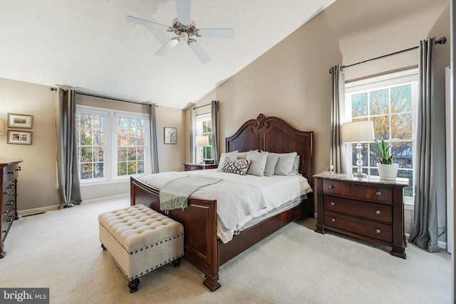 bedroom with light colored carpet, vaulted ceiling, baseboards, and ceiling fan