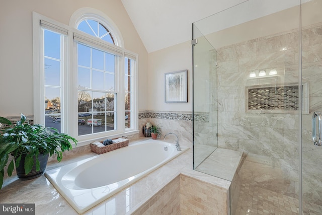 full bath with lofted ceiling, a shower stall, and a garden tub