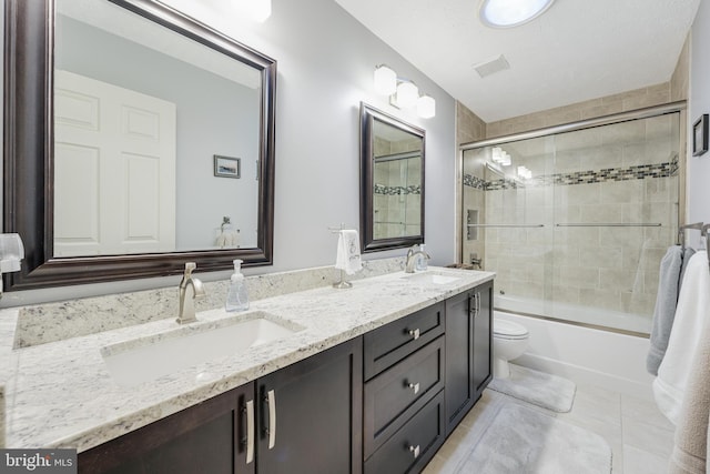 full bath featuring double vanity, visible vents, toilet, and a sink