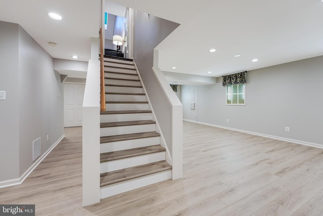 stairway with baseboards, wood finished floors, visible vents, and recessed lighting