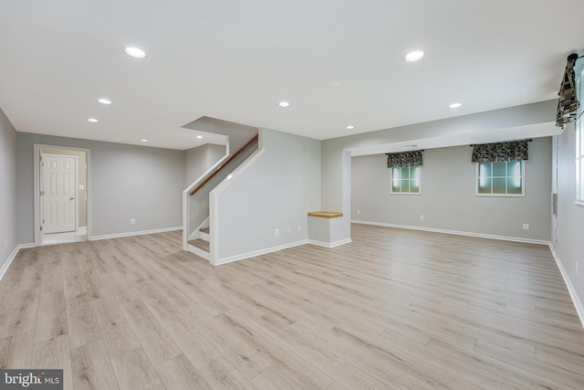 basement with stairway, recessed lighting, and light wood-style floors