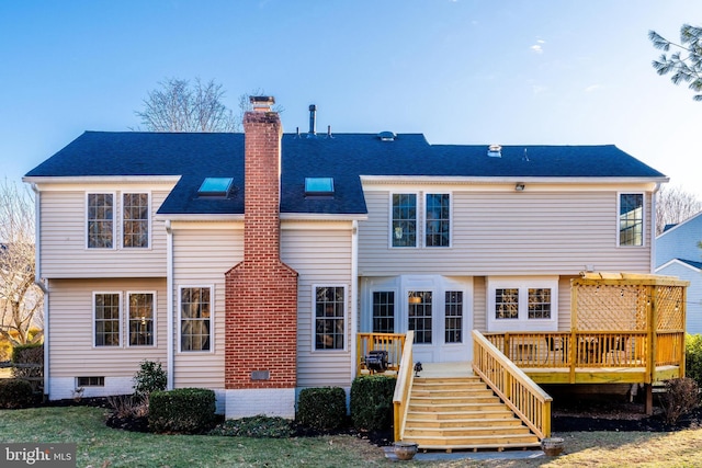 rear view of house featuring stairway, a shingled roof, a chimney, and a deck