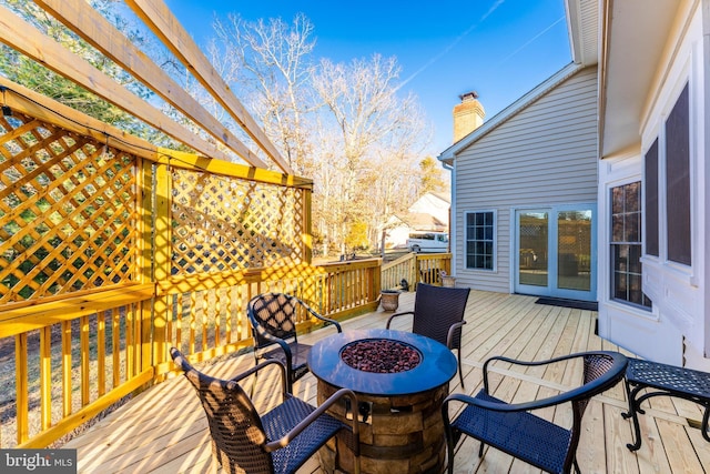 deck featuring an outdoor fire pit and a pergola