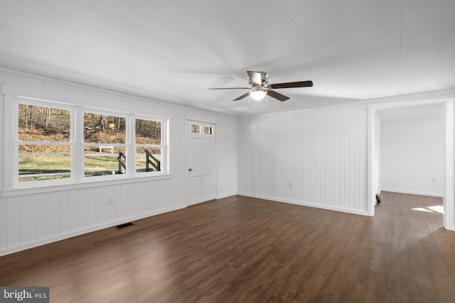 spare room featuring dark wood-style flooring, visible vents, ceiling fan, and baseboards