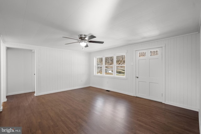 spare room featuring a ceiling fan, dark wood-style flooring, visible vents, and baseboards