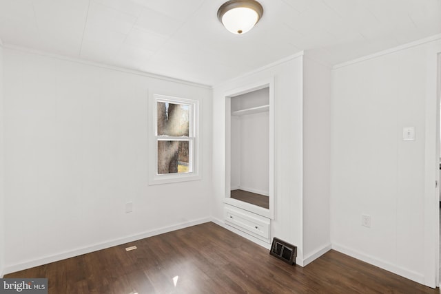 unfurnished bedroom with dark wood-style floors, a closet, visible vents, and crown molding