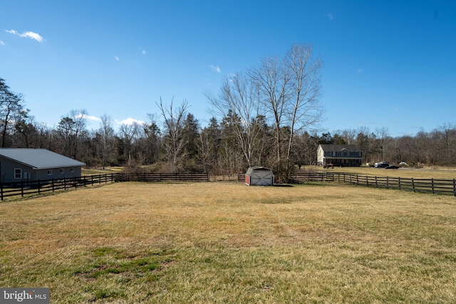 view of yard featuring an outbuilding, a shed, and fence