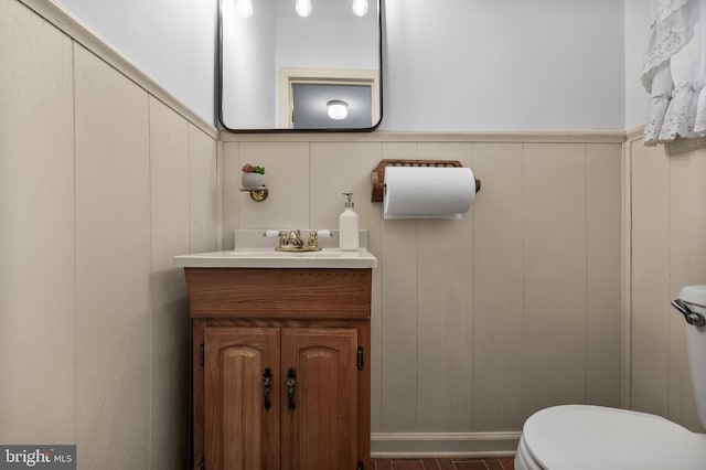 bathroom featuring wainscoting, vanity, and toilet