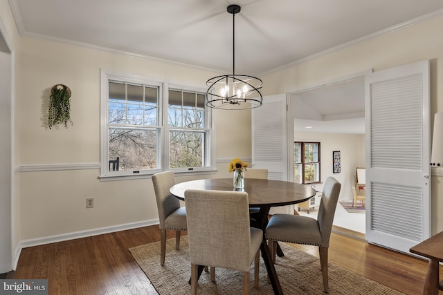 dining space with ornamental molding, hardwood / wood-style flooring, and baseboards