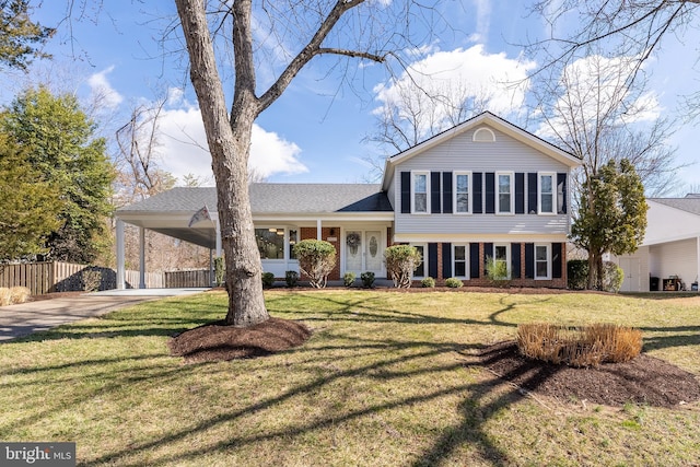 tri-level home with driveway, a front yard, fence, and brick siding