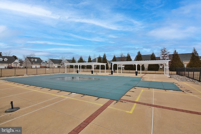 pool featuring a patio area, a residential view, fence, and a pergola