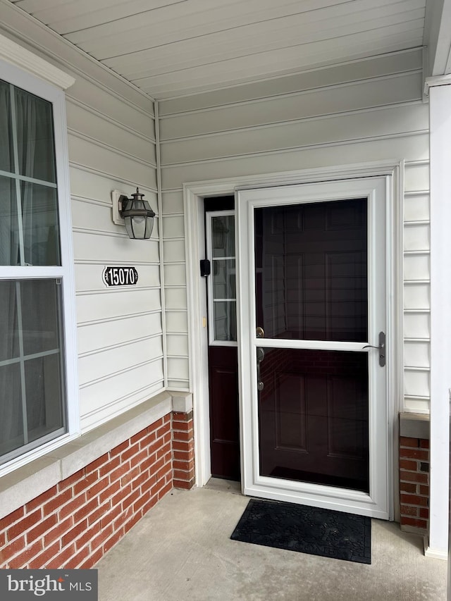 view of exterior entry with brick siding