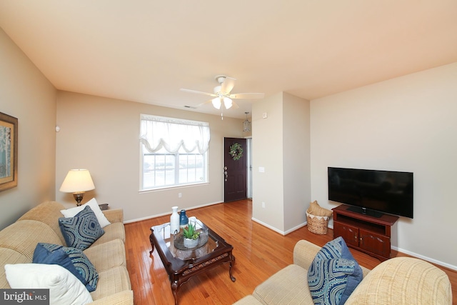 living area with visible vents, ceiling fan, baseboards, and wood finished floors