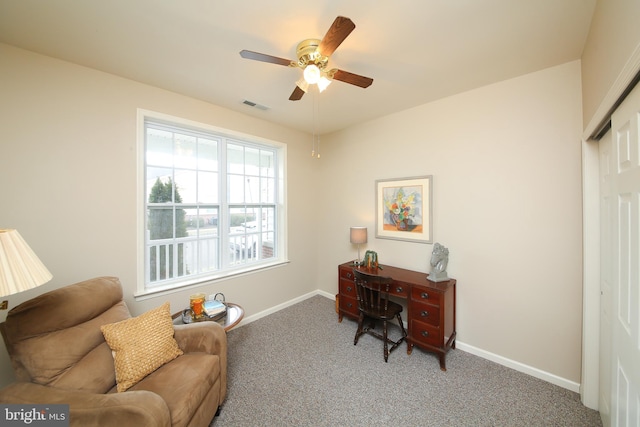 carpeted office space featuring baseboards, visible vents, and a ceiling fan