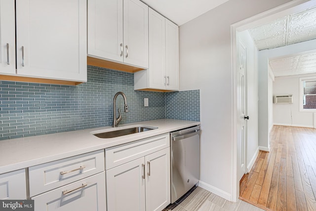 kitchen with a sink, white cabinetry, light countertops, and stainless steel dishwasher