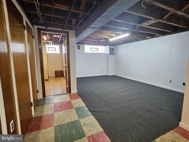 basement with dark floors and baseboards