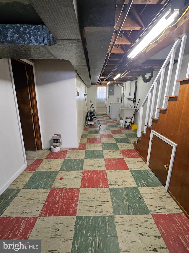 basement featuring stairs, a sink, electric panel, and tile patterned floors