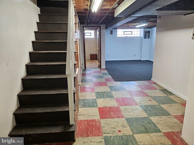 basement with stairs, baseboards, and tile patterned floors