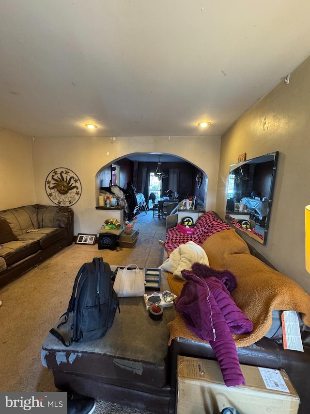 carpeted living room featuring arched walkways