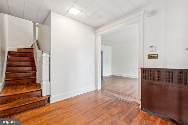 staircase featuring wood finished floors and baseboards