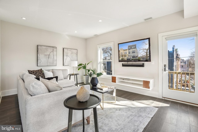 living area featuring dark wood-type flooring, recessed lighting, visible vents, and baseboards