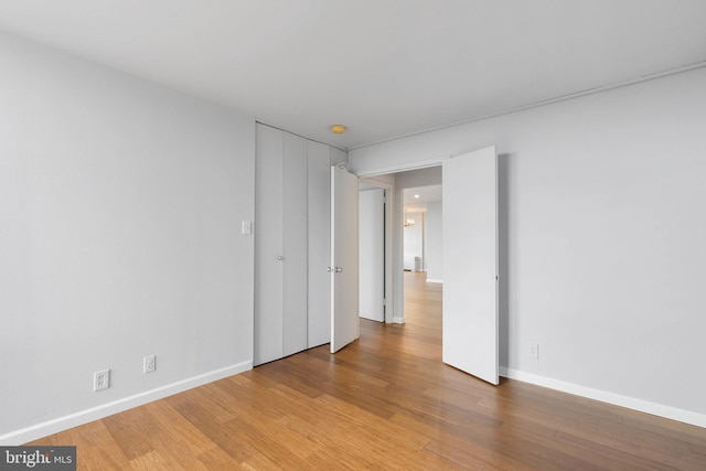 spare room featuring wood finished floors and baseboards