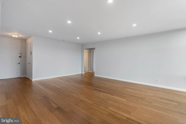 empty room featuring baseboards, recessed lighting, and light wood-style floors