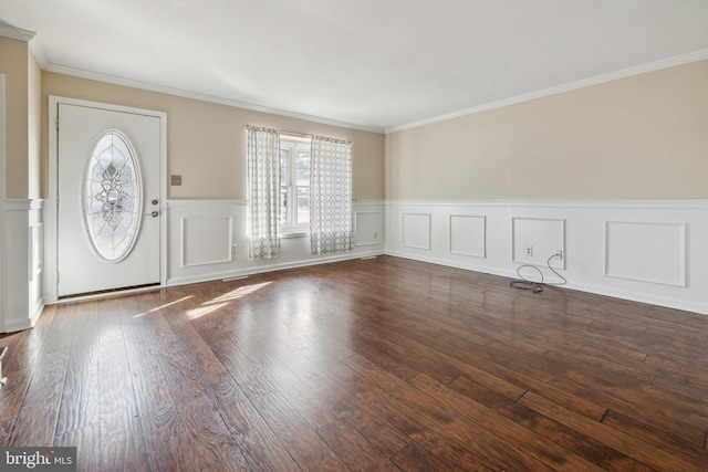 foyer with dark wood-type flooring, wainscoting, and crown molding