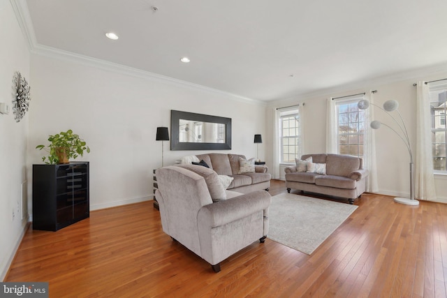 living area with baseboards, recessed lighting, light wood-style flooring, and crown molding