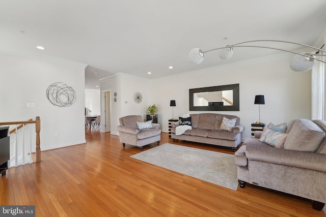 living room featuring hardwood / wood-style flooring, baseboards, ornamental molding, and recessed lighting
