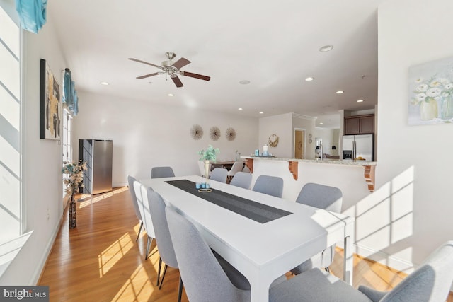 dining space with a ceiling fan, recessed lighting, baseboards, and light wood finished floors